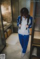 A woman standing in a bathroom with a backpack.