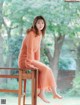 A woman sitting on top of a wooden chair.