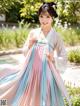 A woman in a blue and pink hanbok is posing for a picture.