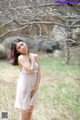 A woman in a white dress standing in a field.