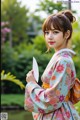 A woman in a kimono holding a fan in her hand.