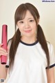 A woman holding a pink curling iron in her hand.