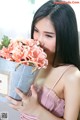 A woman holding a bucket of flowers in her hands.